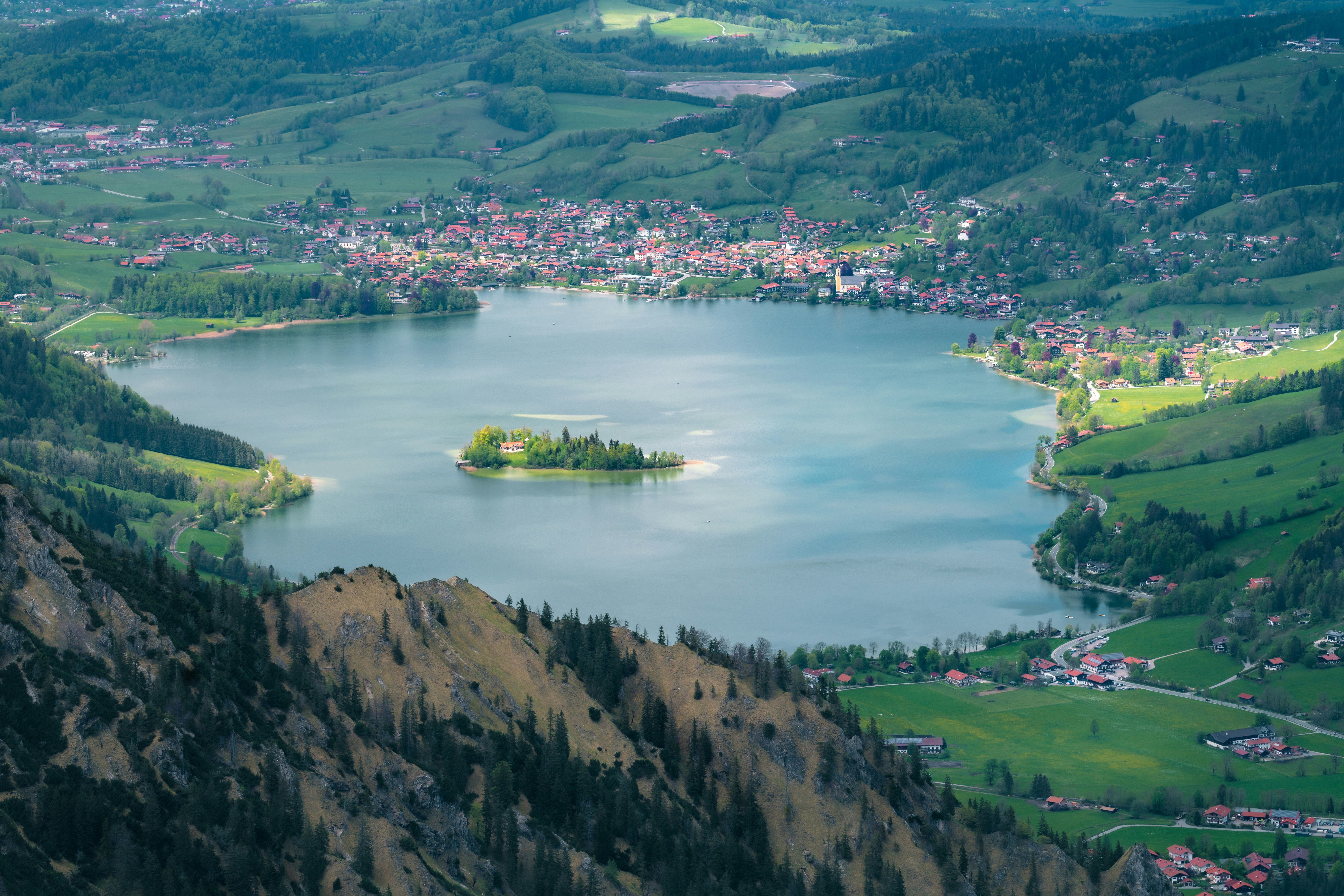 aerial view of green and brown mountains near lake during daytime